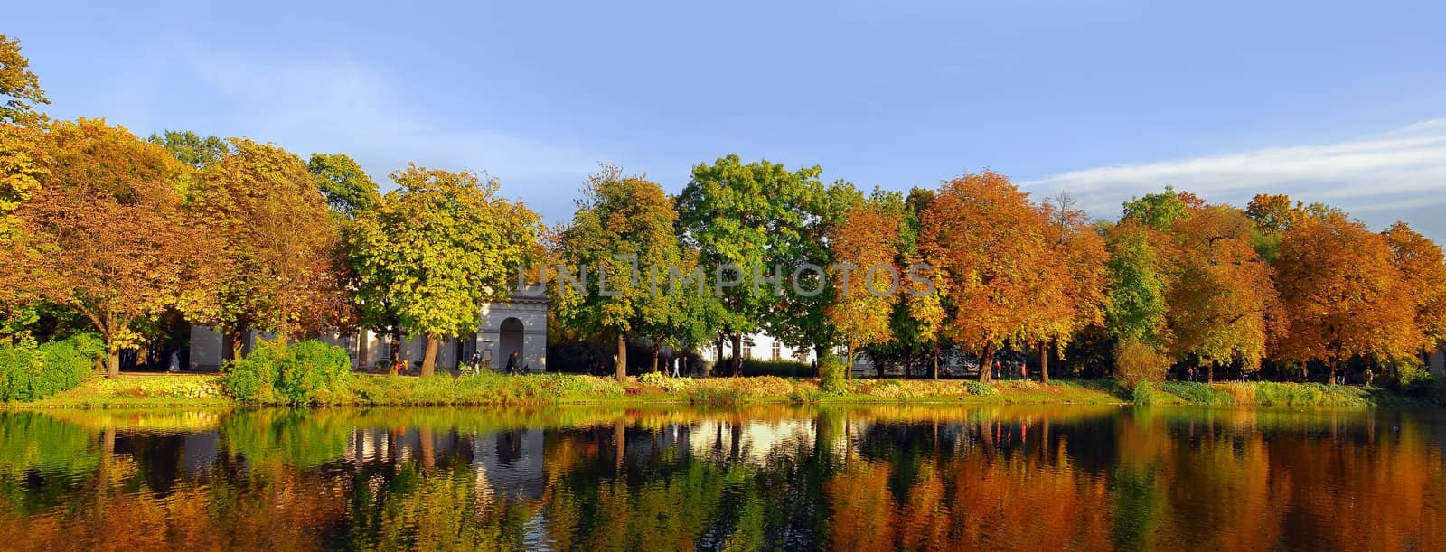 Walking area around the lake in Lazienki park in Warsaw. Panoramic view. People faces not recognisable.