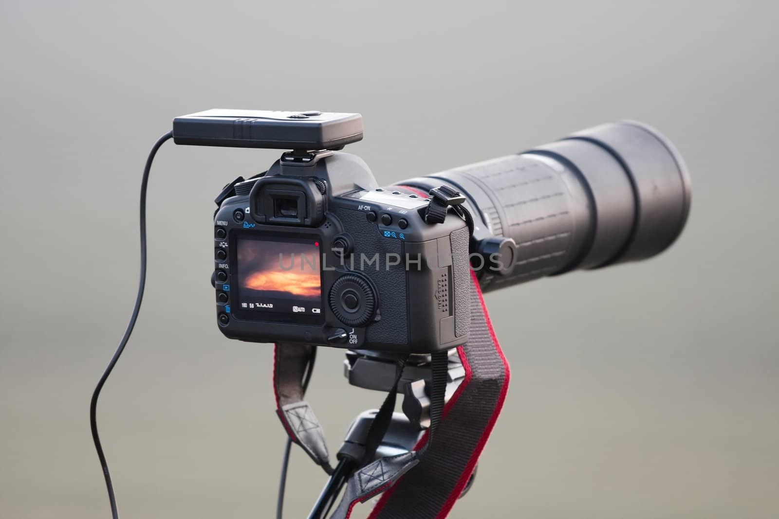 SLR camera on tripod with telephoto lens