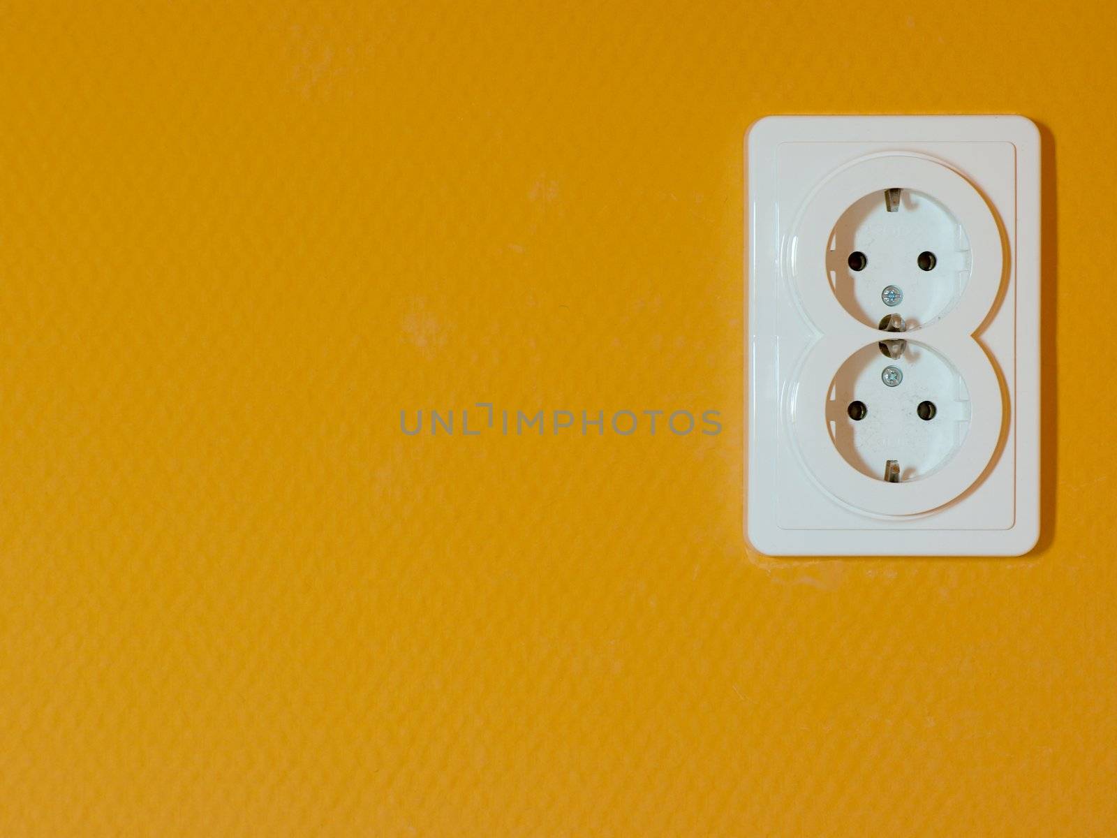 electric outlet socket on orange wall