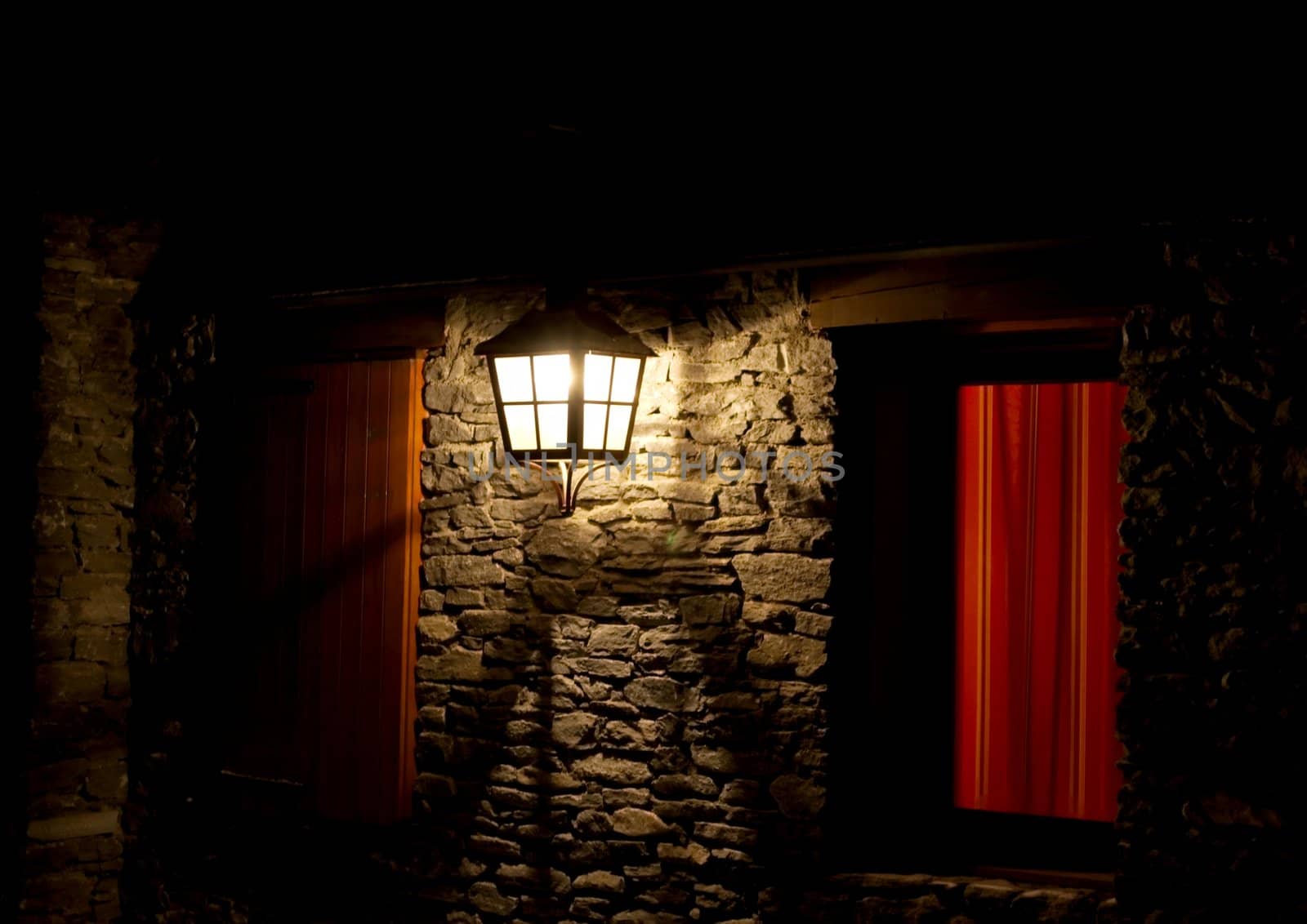 Old fashioned lamp illuminating a wall at night
