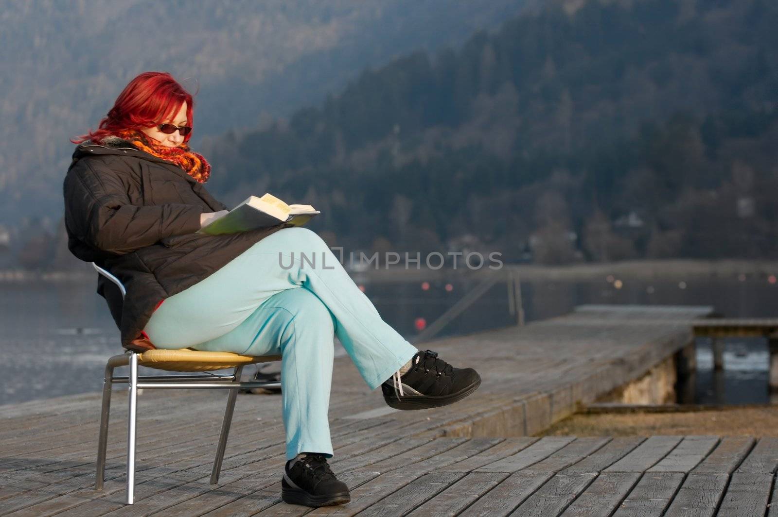 Woman reading a book outside in autumn