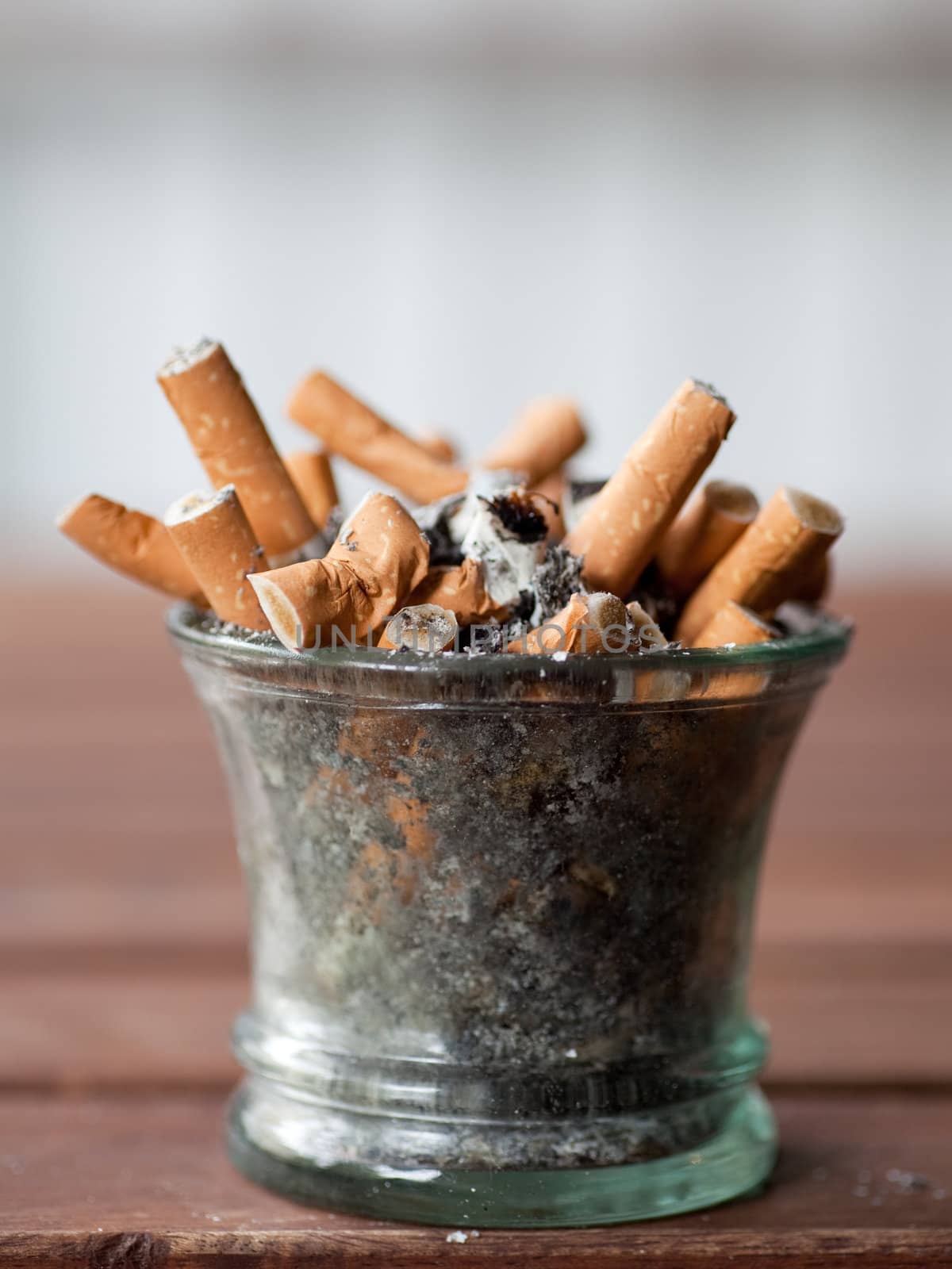 ashtray full with butts on dirty table