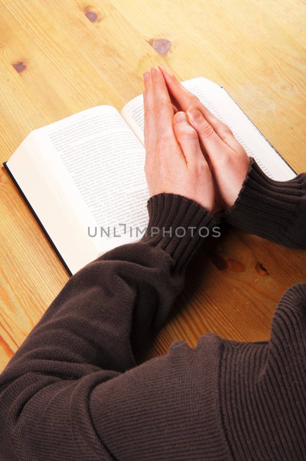 praying hands and book showing christian religion concept