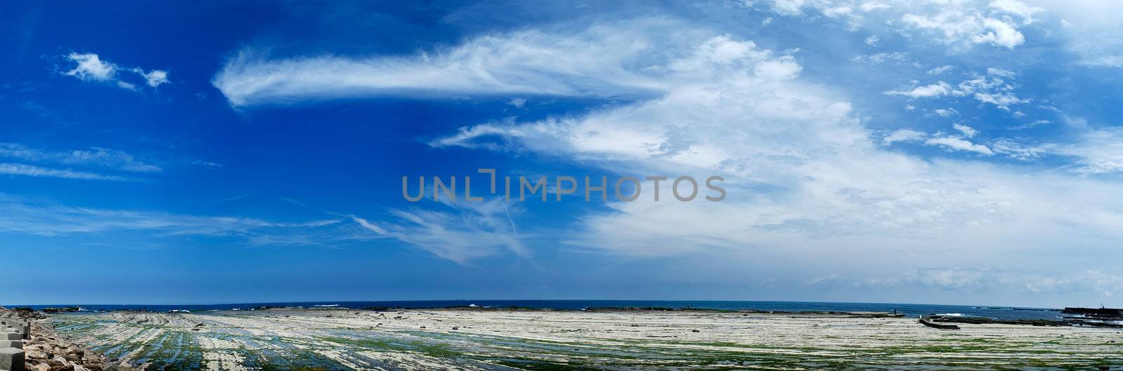It is a beautiful panorama blue sky and beach.