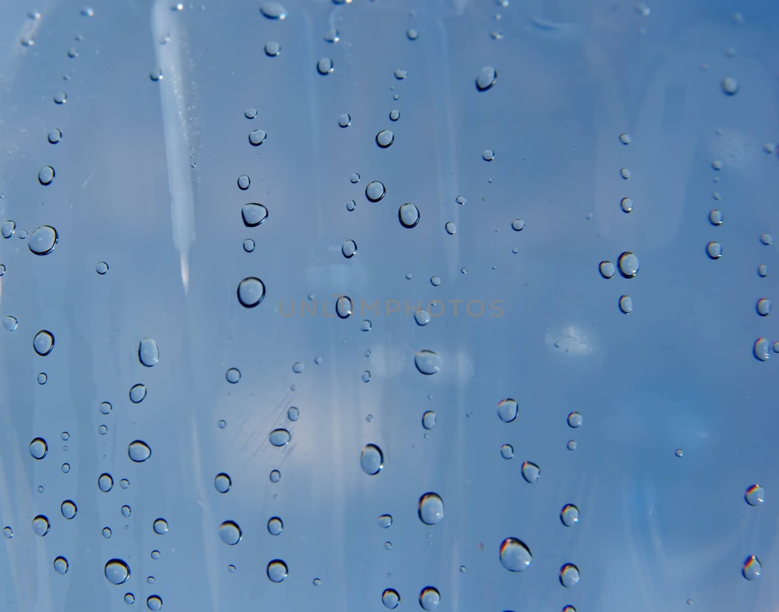 Many small droplets on a transparent blue surface