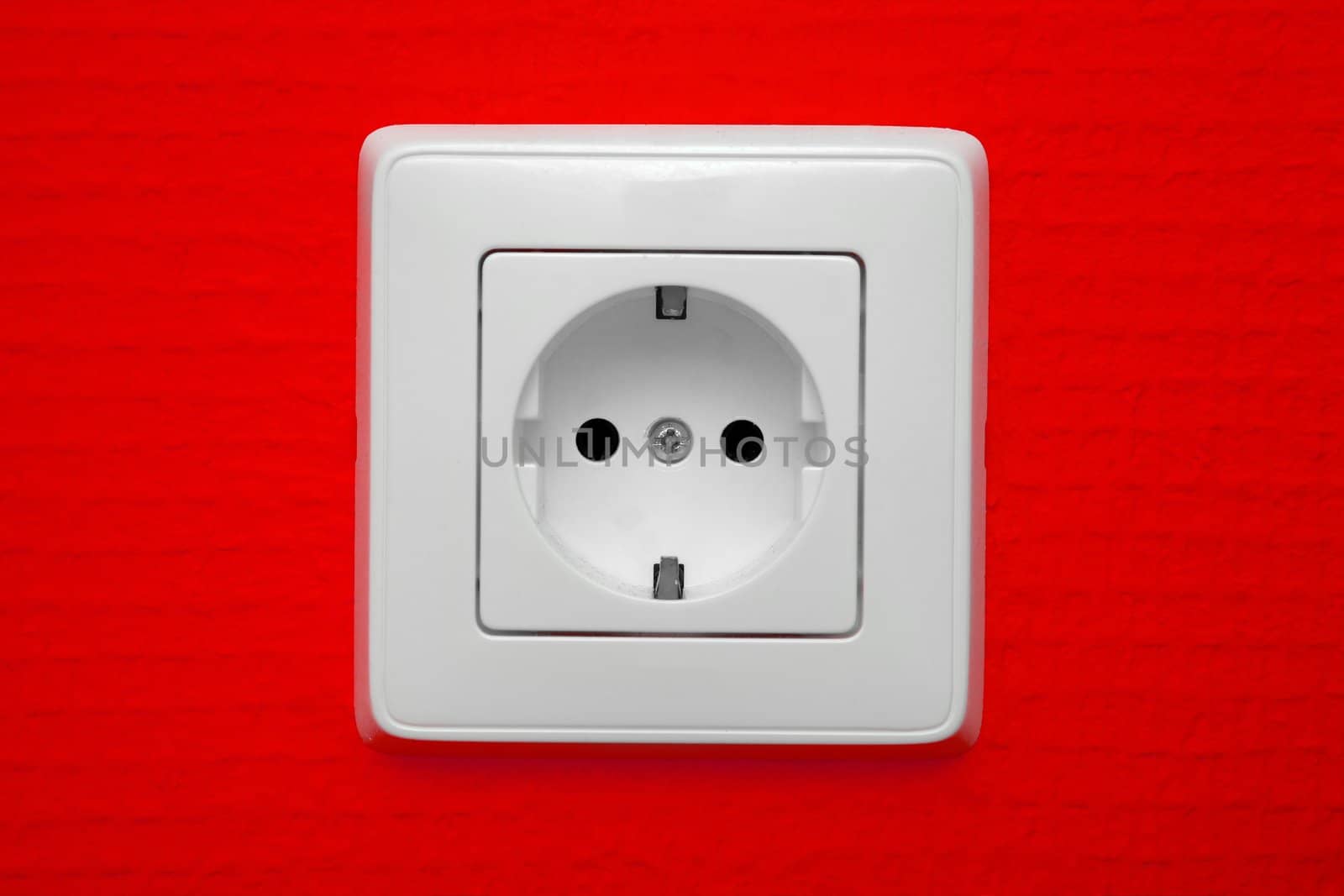 Empty electric socket on red wall