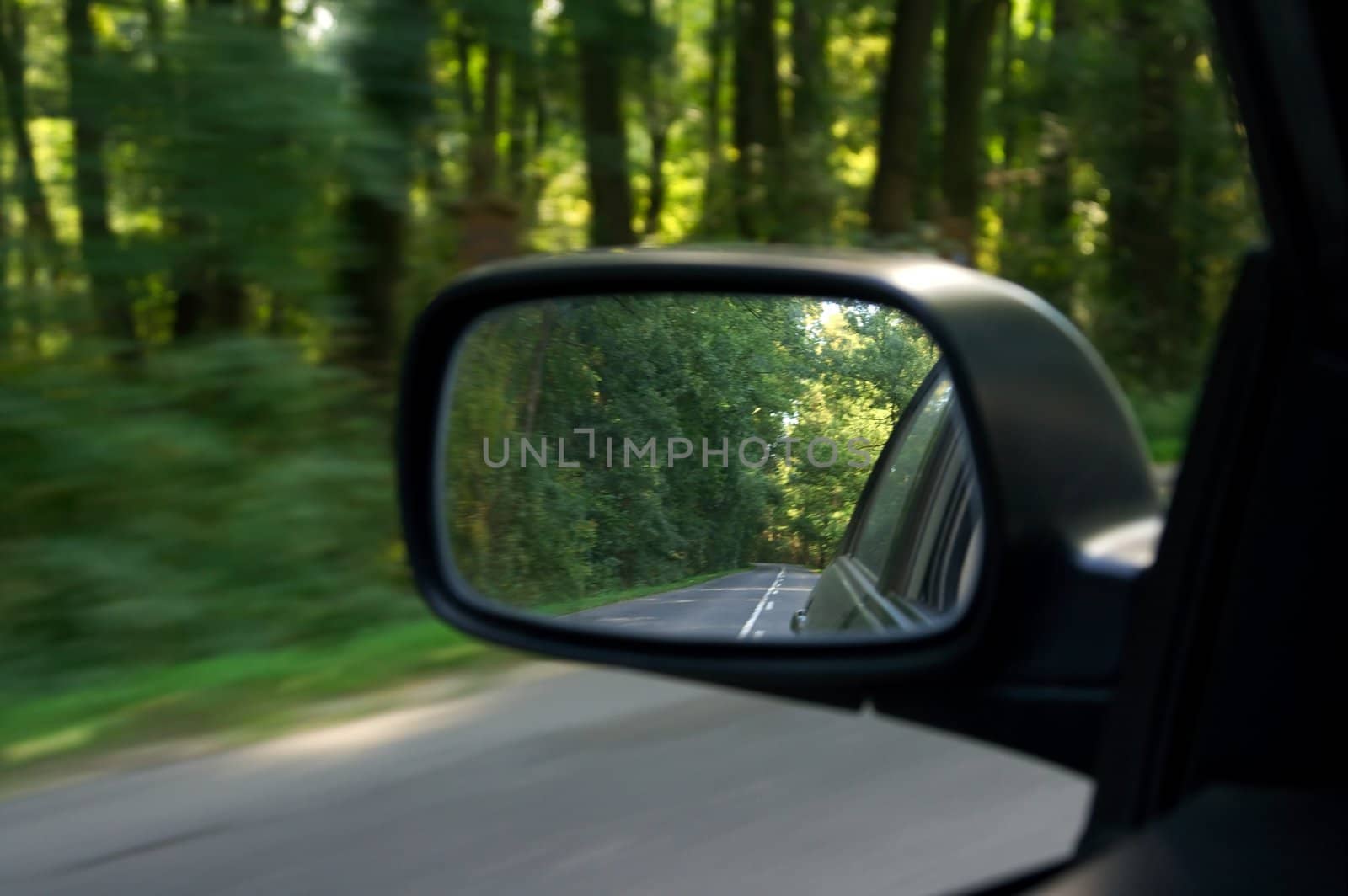 Sideview mirror of a car driving on the road