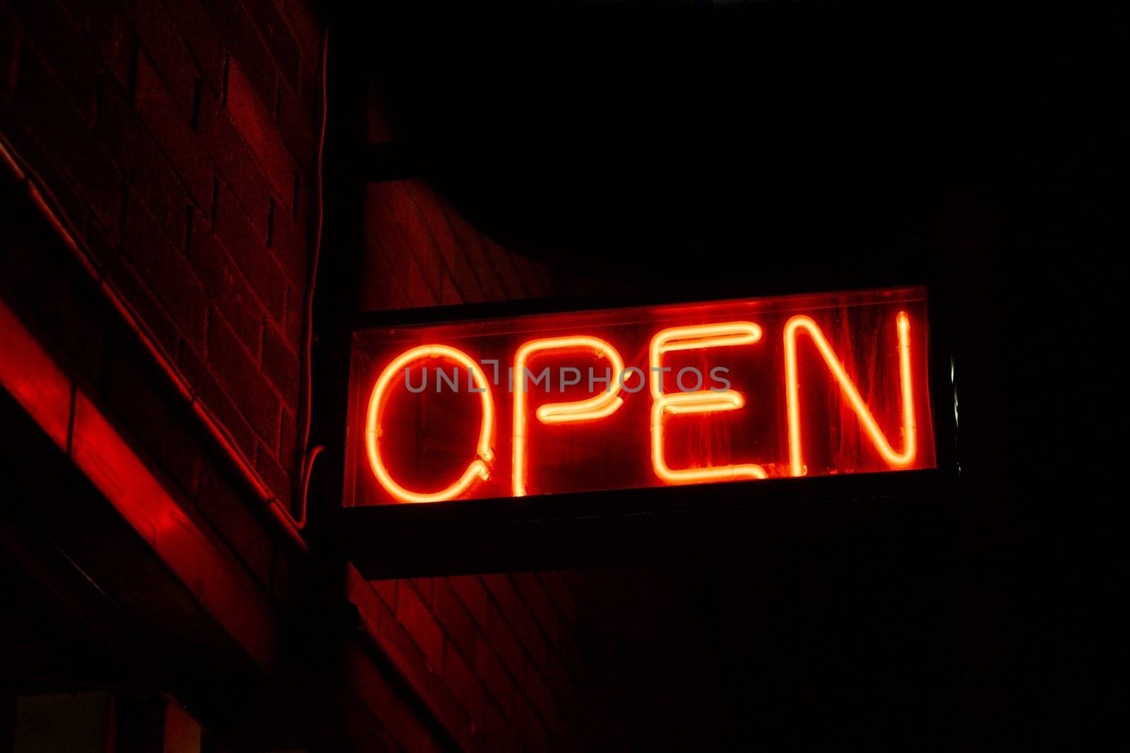 Red open neon sign glowing in the night