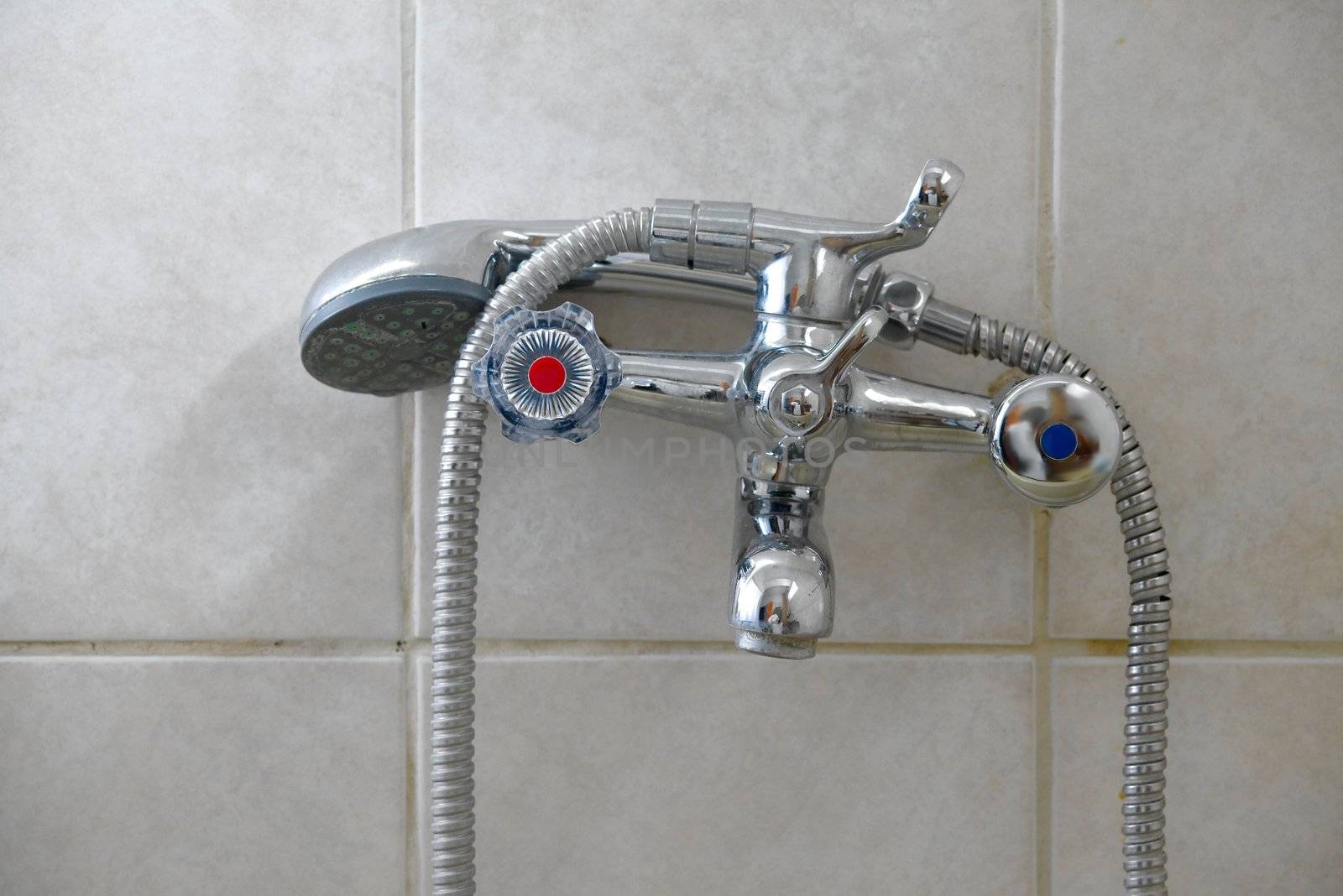 Shower tap faucet on tiled wall