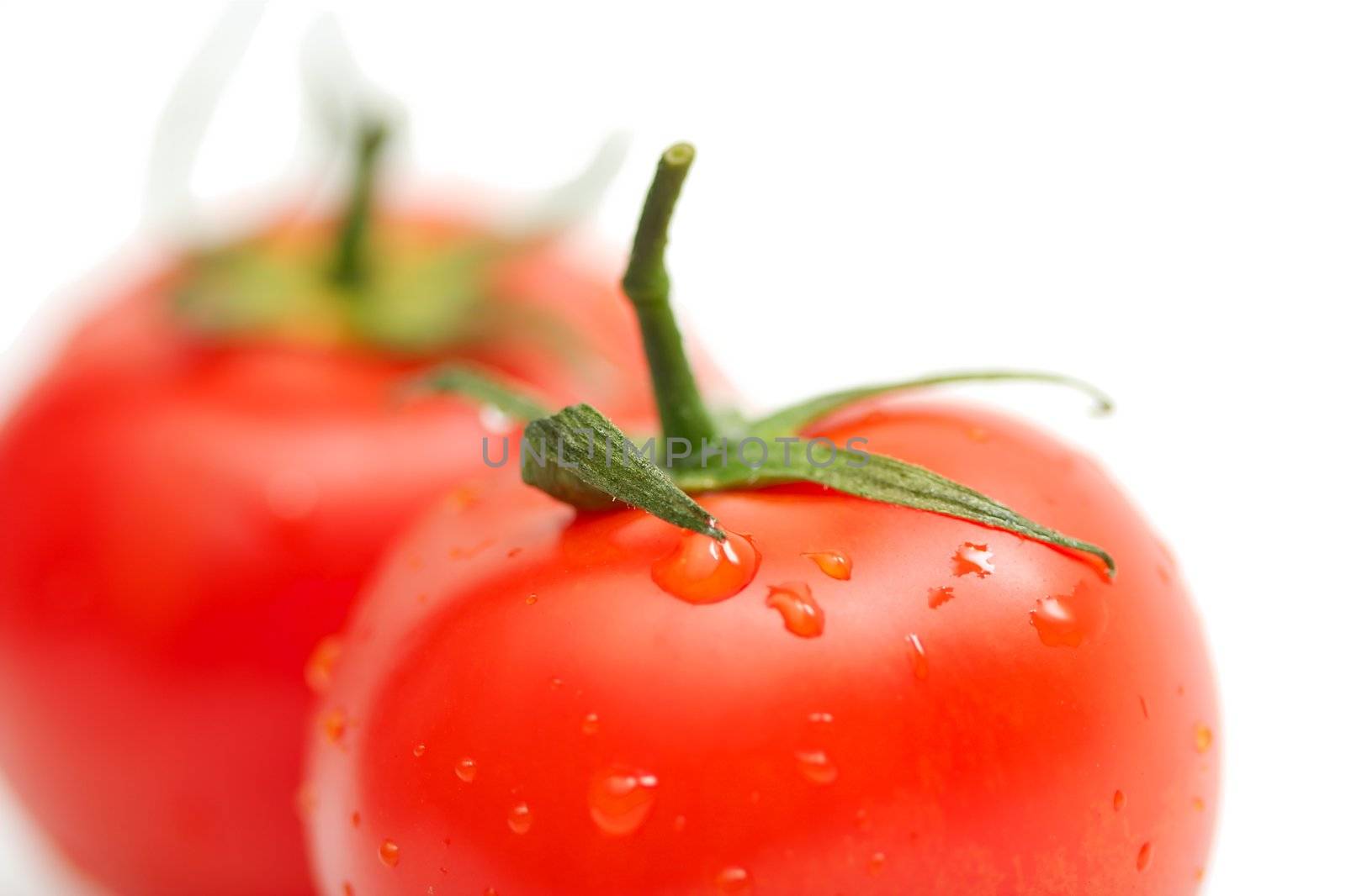 Two perfect red tomatoes on white background