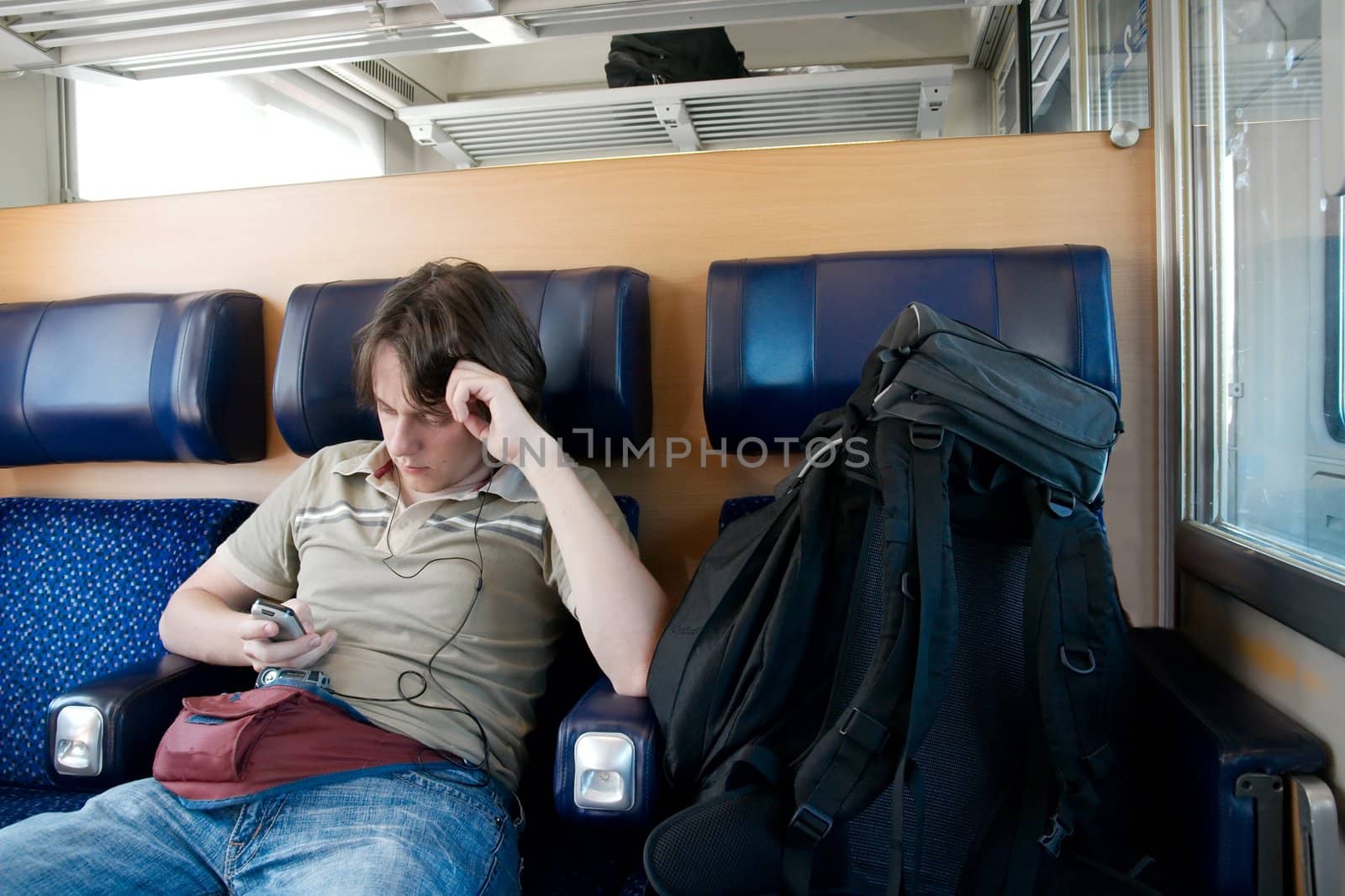 Young man traveling by train with backpack