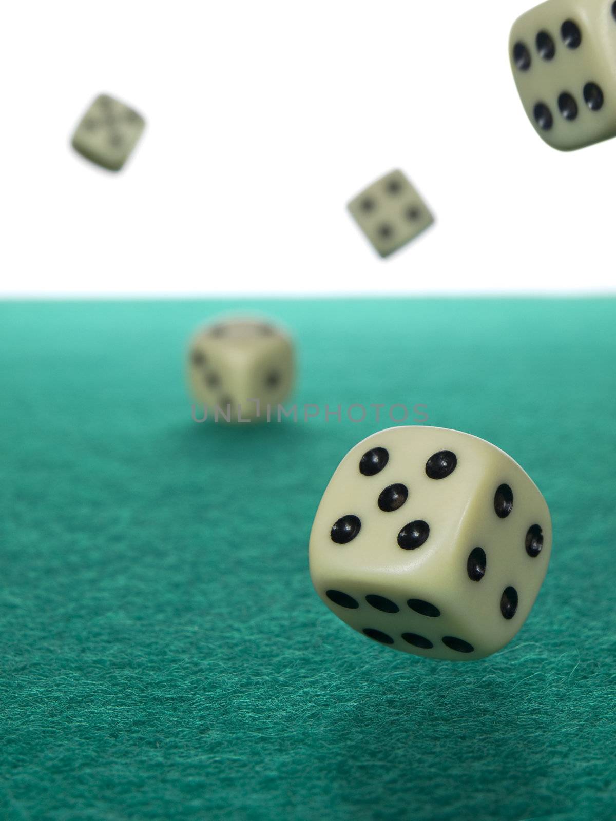 Five dices rolling over a green felt.