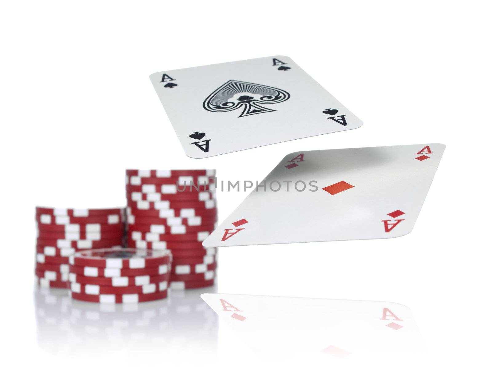 Two aces flying over a game table beside three piles of red chips. Isolated on white.