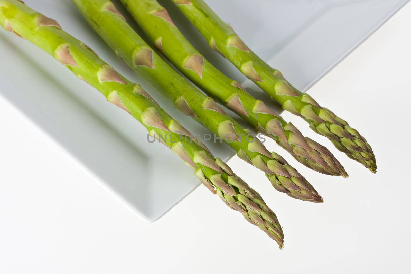 detail of fresh green asparagus isolated on white background by bernjuer