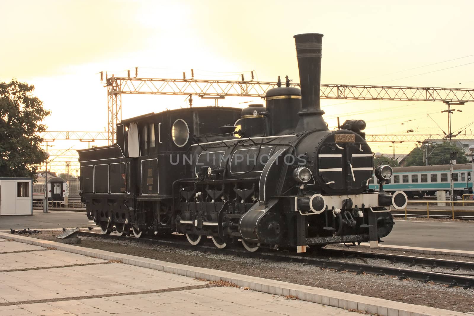 An old engine on last station in sunrise