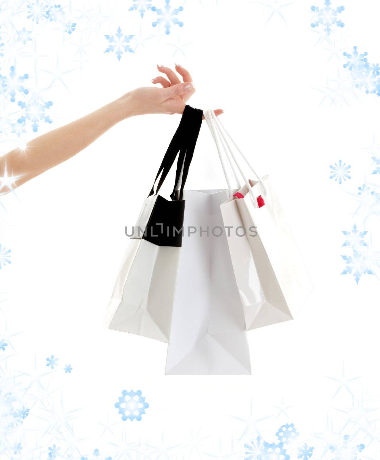 hand with three shopping bags and snowflakes