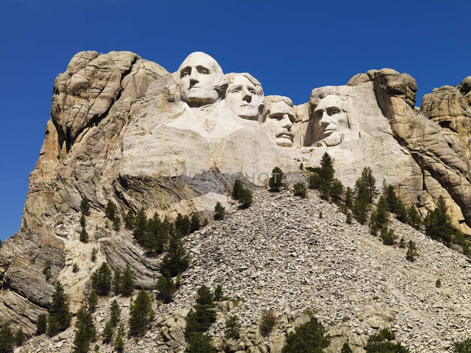 Mount Rushmore National Memorial with mountain and trees.