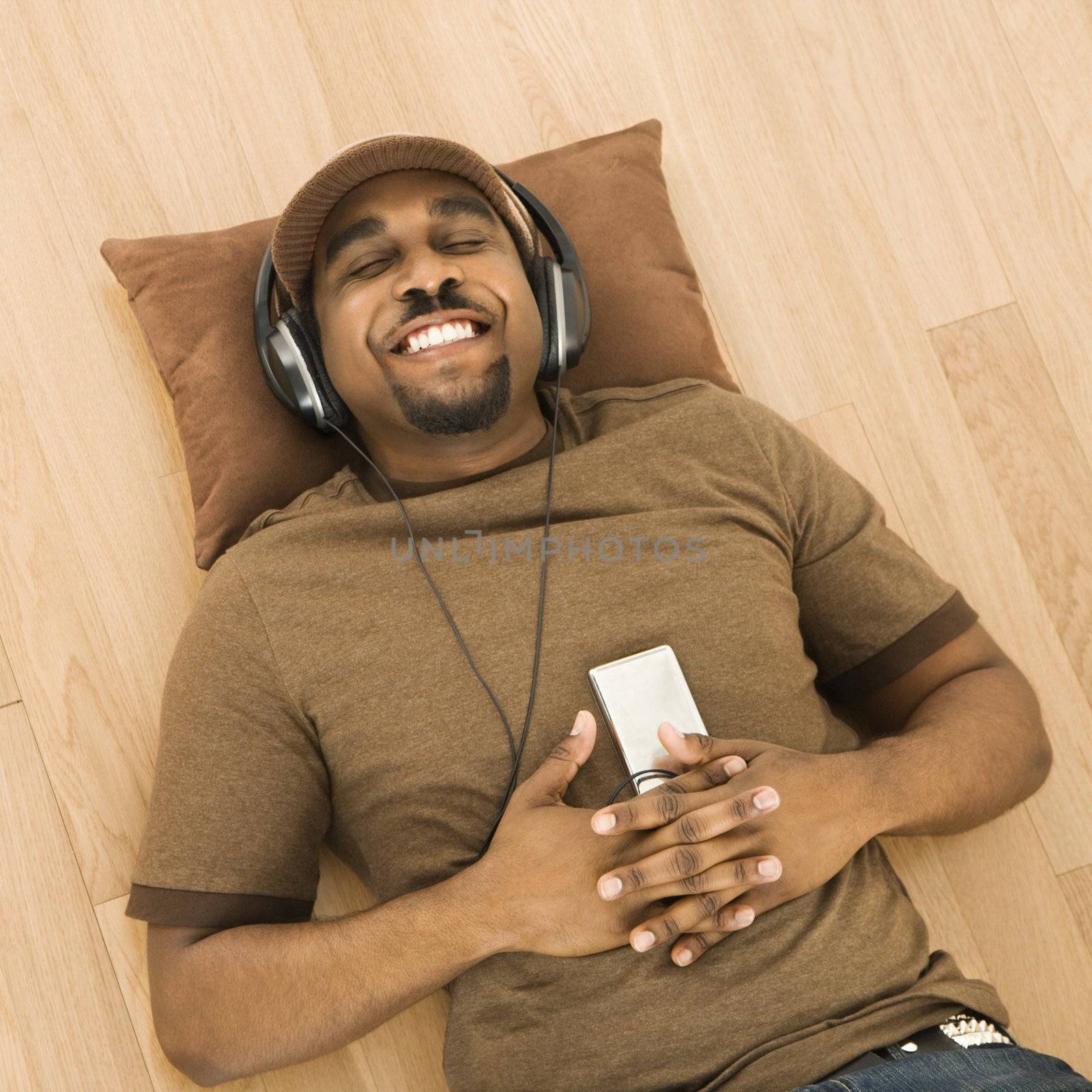 Man relaxing to music. by iofoto