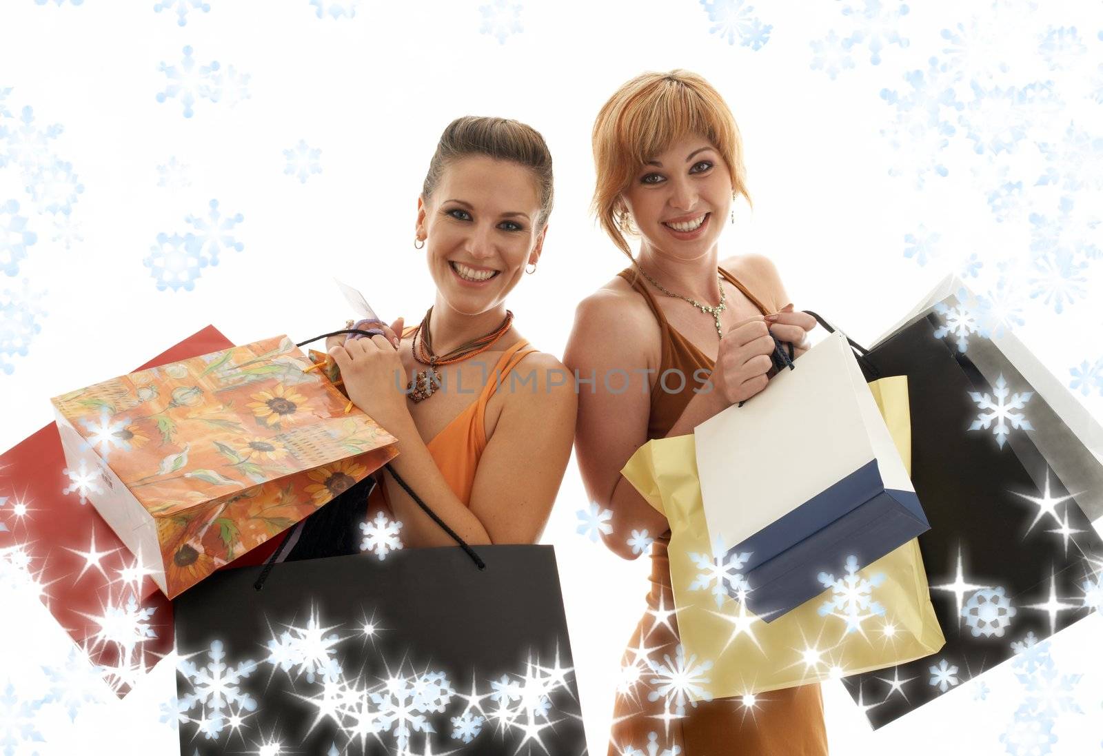 two happy girls with shopping bags and snowflakes