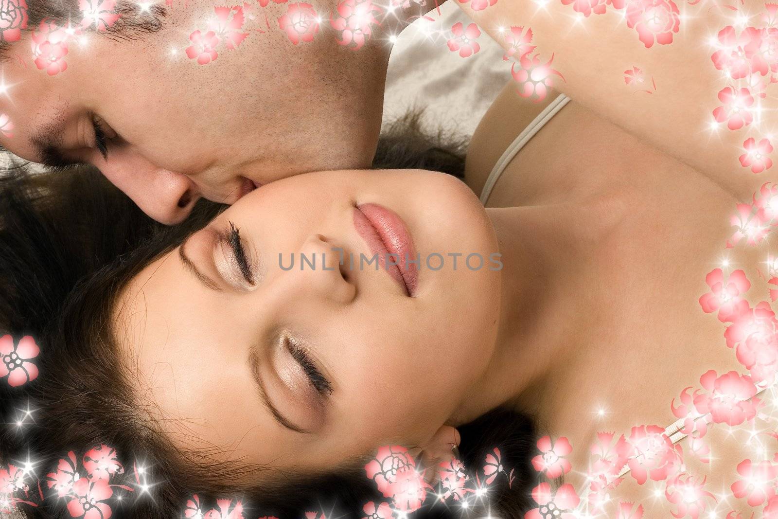 picture of couple cuddling in bed with flowers