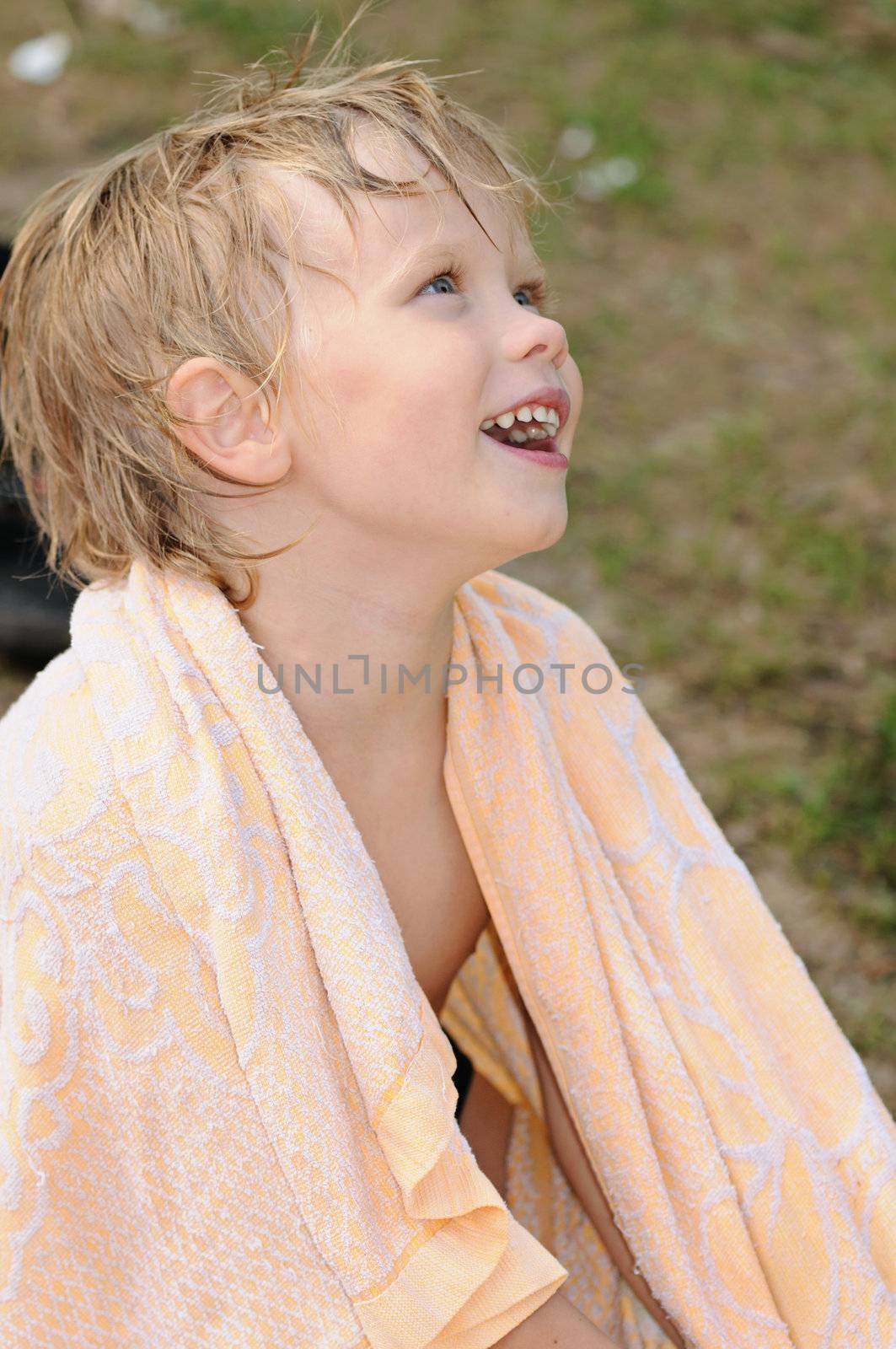 Smiling the wet child wrapped up in a towel