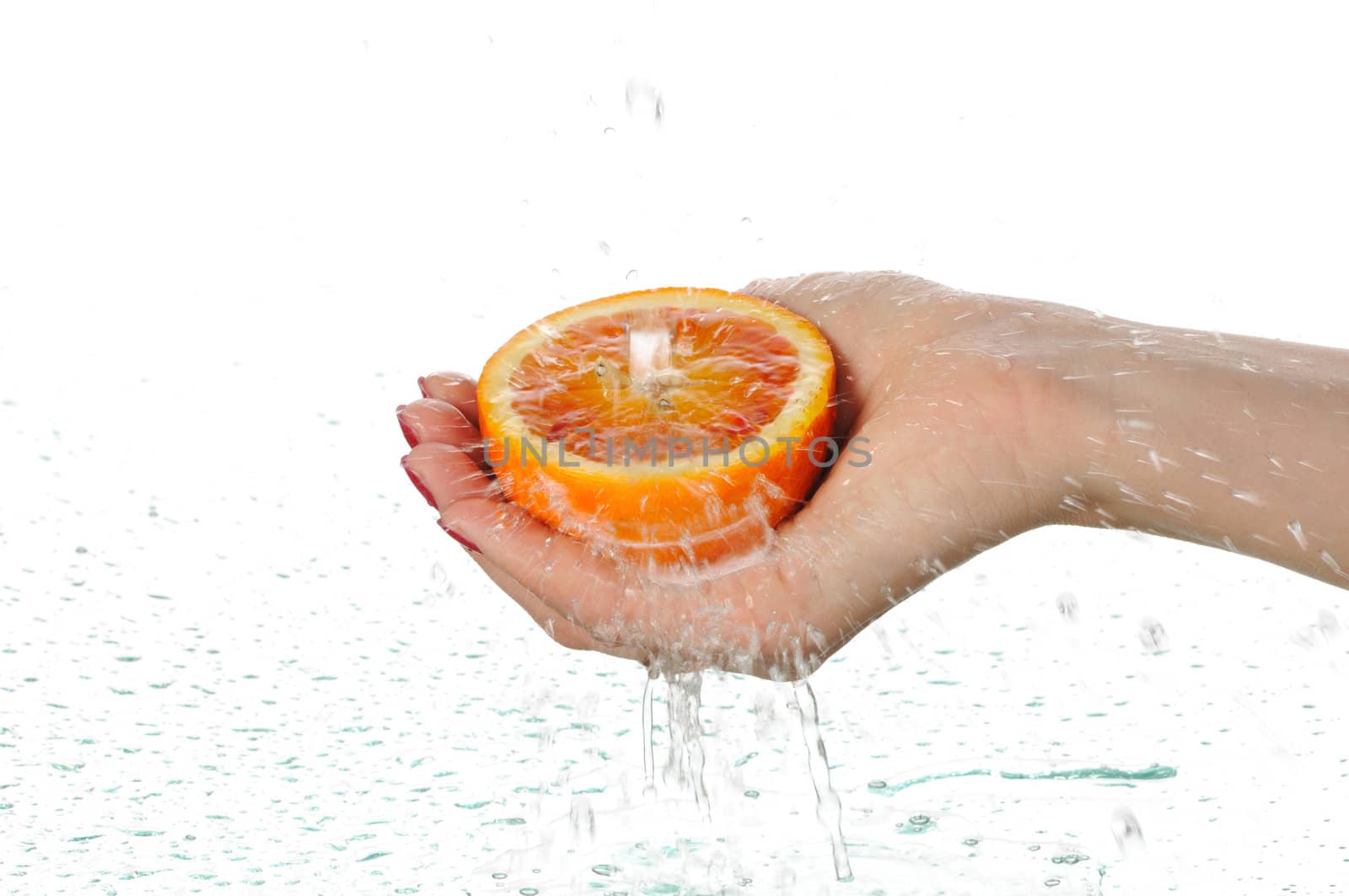 To wash a red orange under water isolated on white background