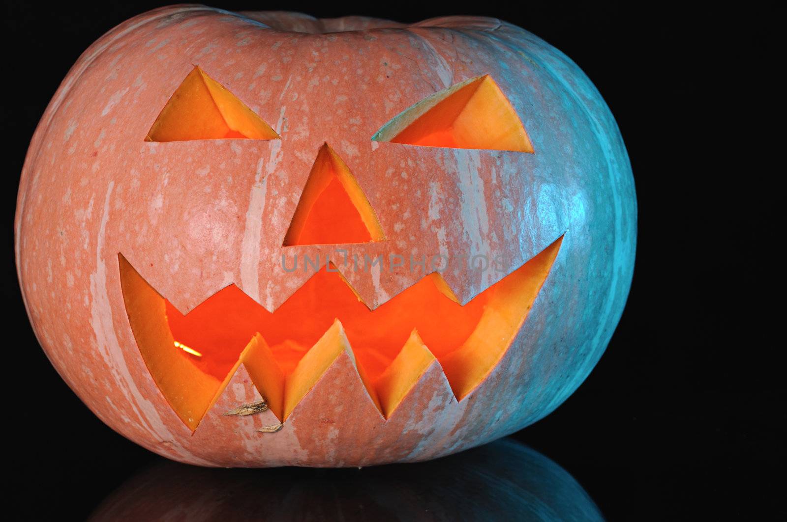  pumpkin with lighting candle inside on black background