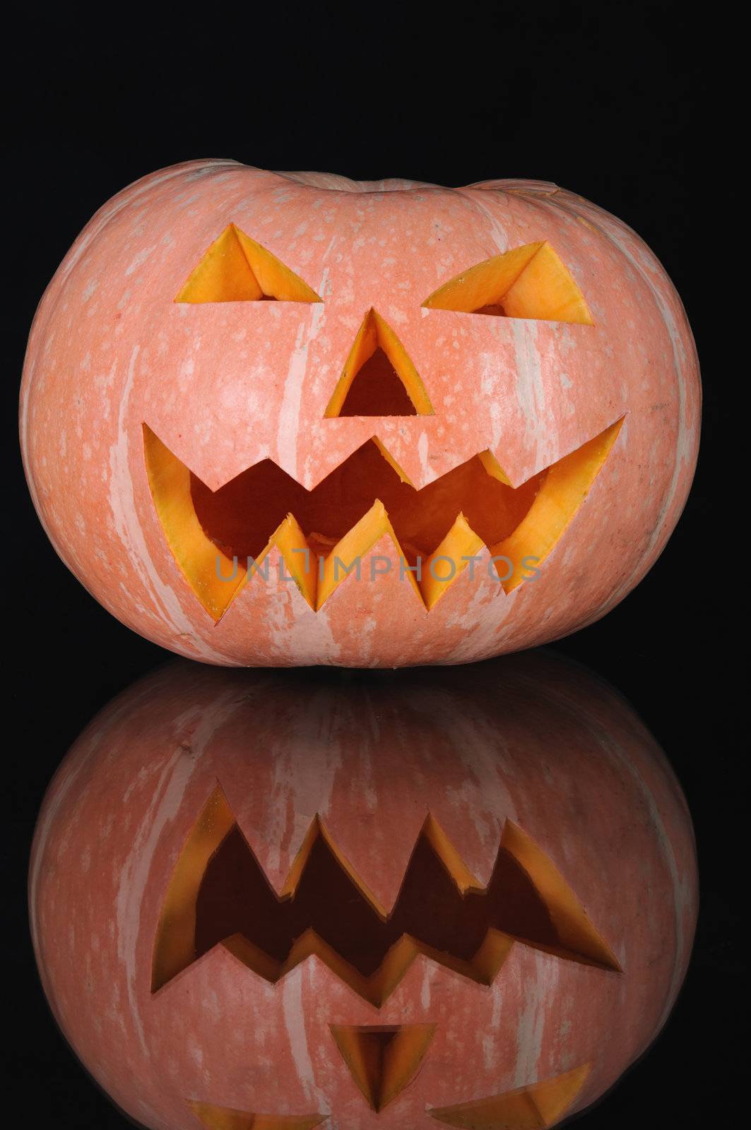  pumpkin with lighting candle inside on black background