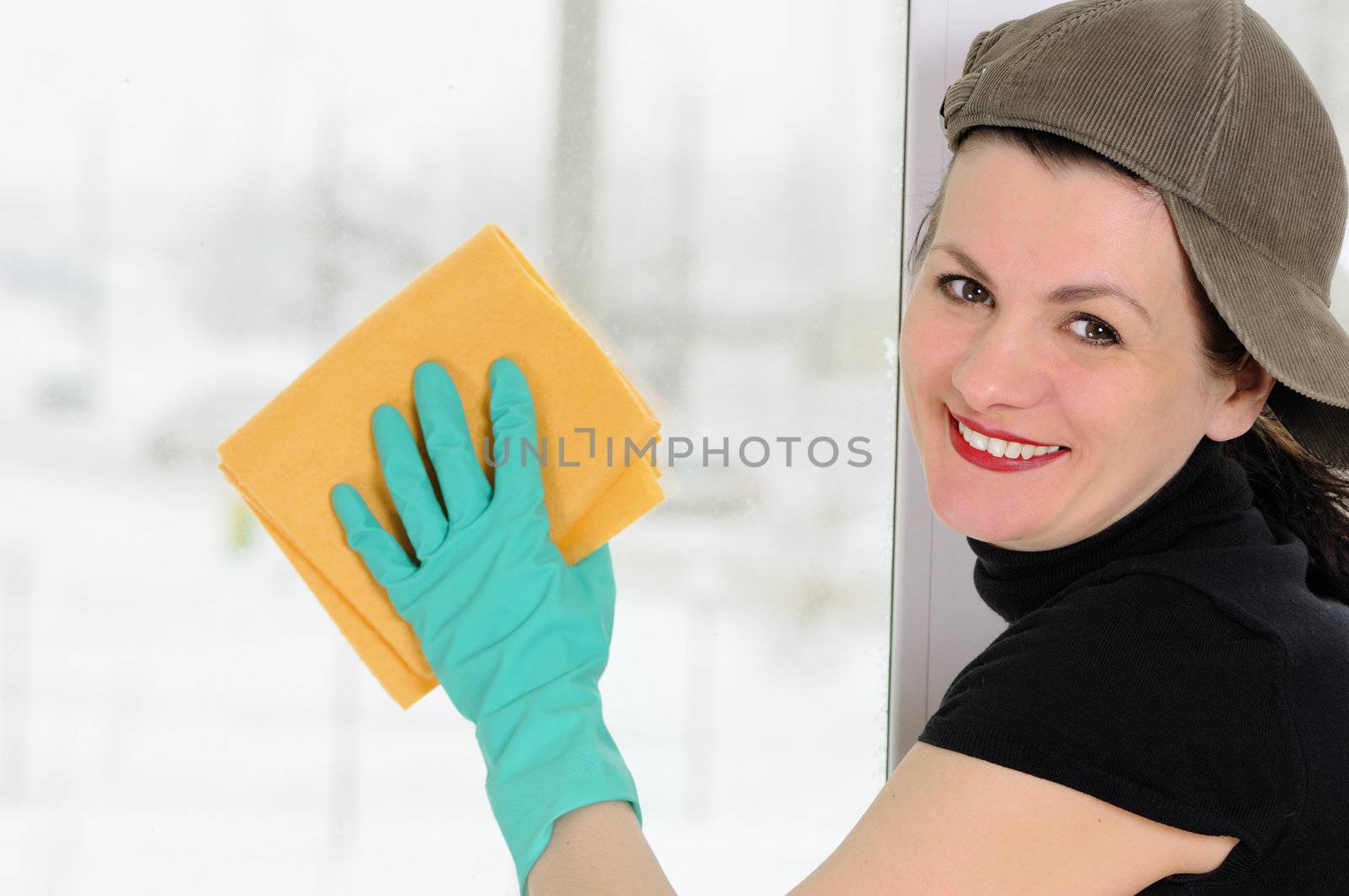 The woman with a yellow rag  washes a window