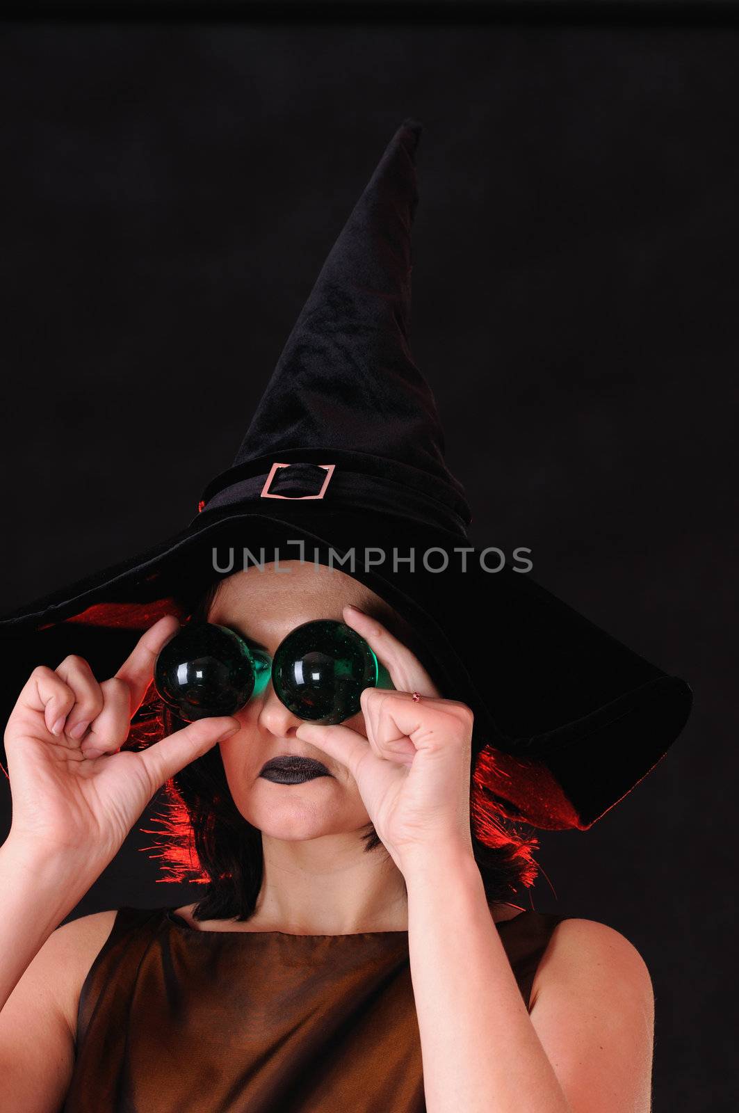 Young witch with glass spheres near eyes