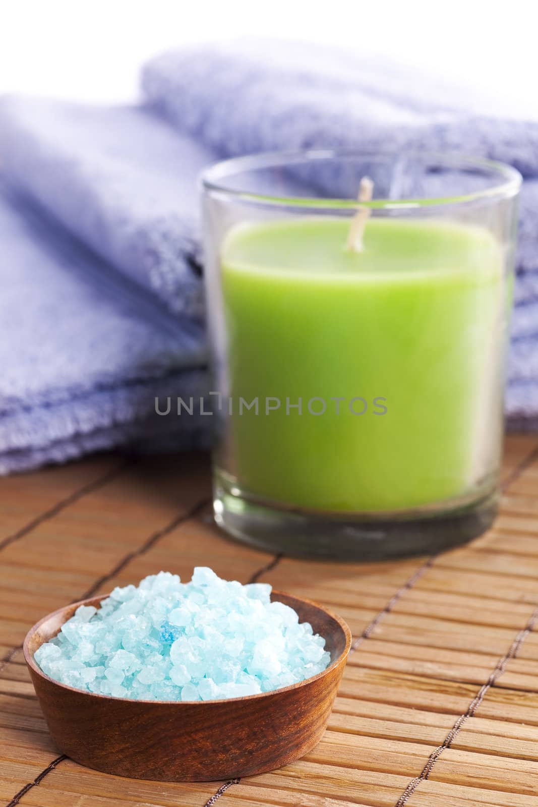 Spa salt, aroma candle and towel over bamboo mat