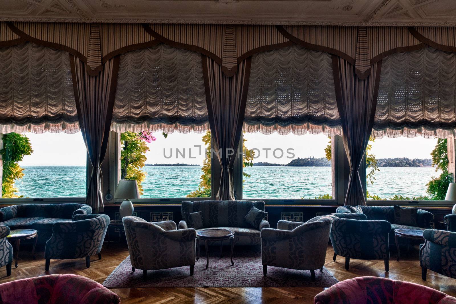 HDR image of luxurious hotel lounge with curtained windows overlooking the lake