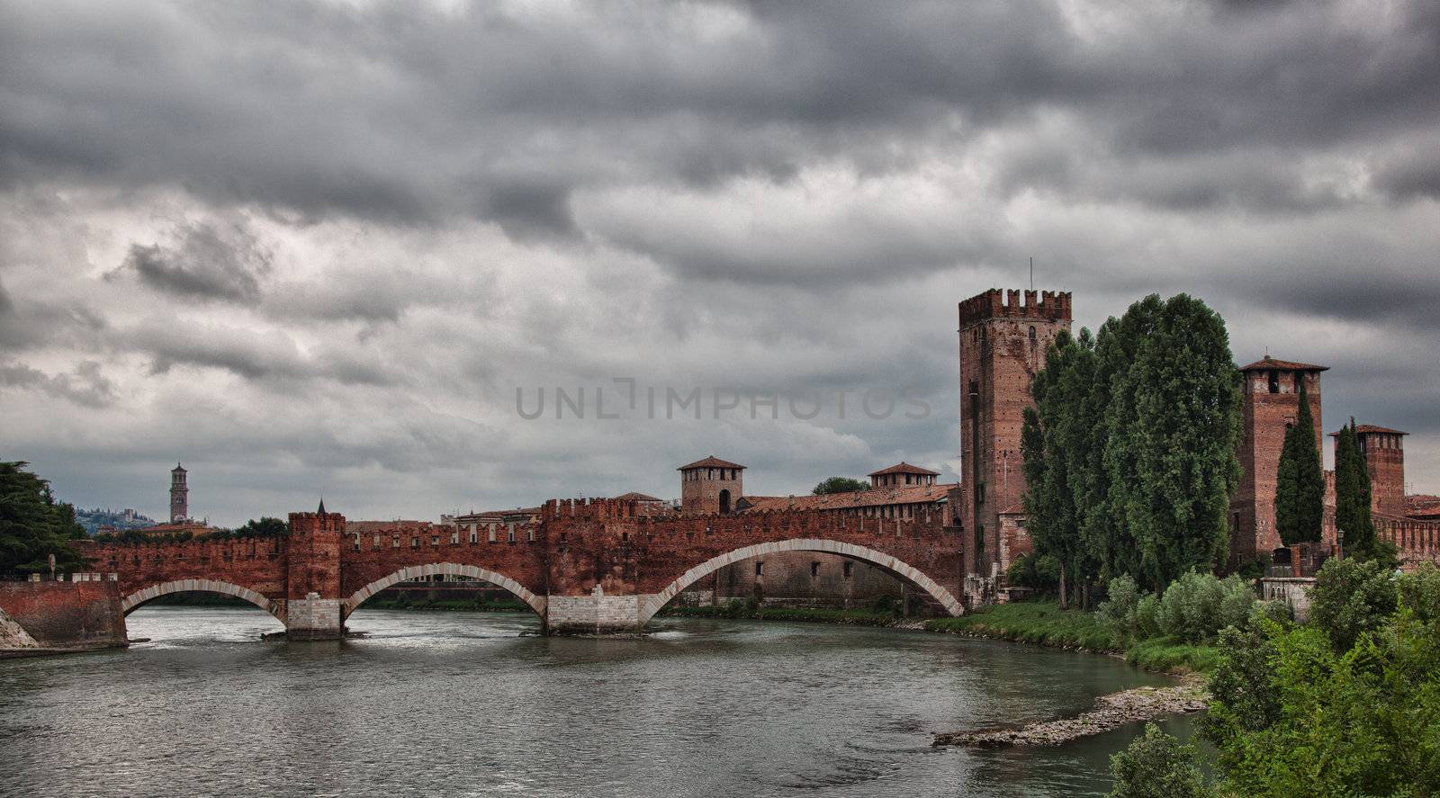 Ponte CastelVecchio in Verona with battlements against the cloudy sky