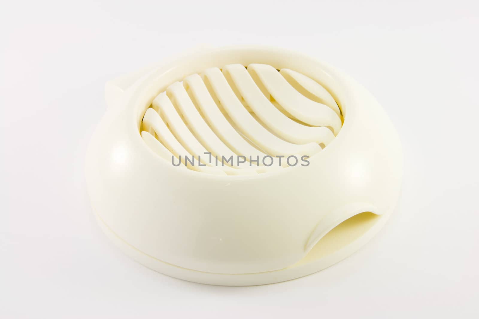 White plastic egg slicer on a whit background
