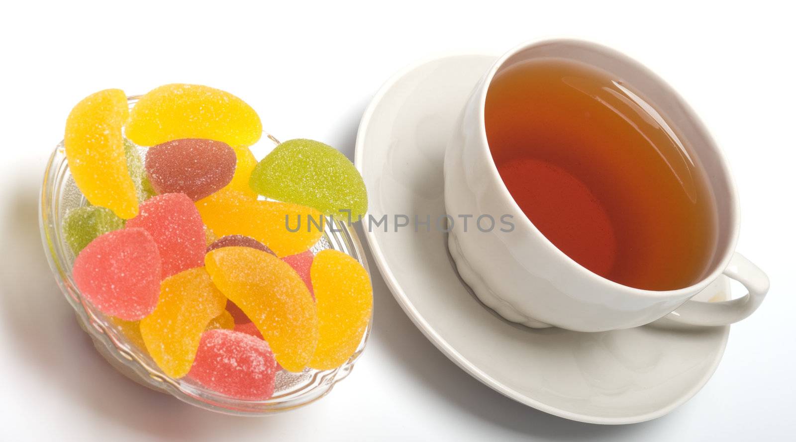 Fruit candy and tea cup. It is isolated on a white background 