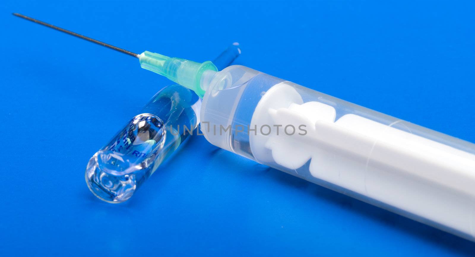 Syringe and ampoule on a dark blue background.