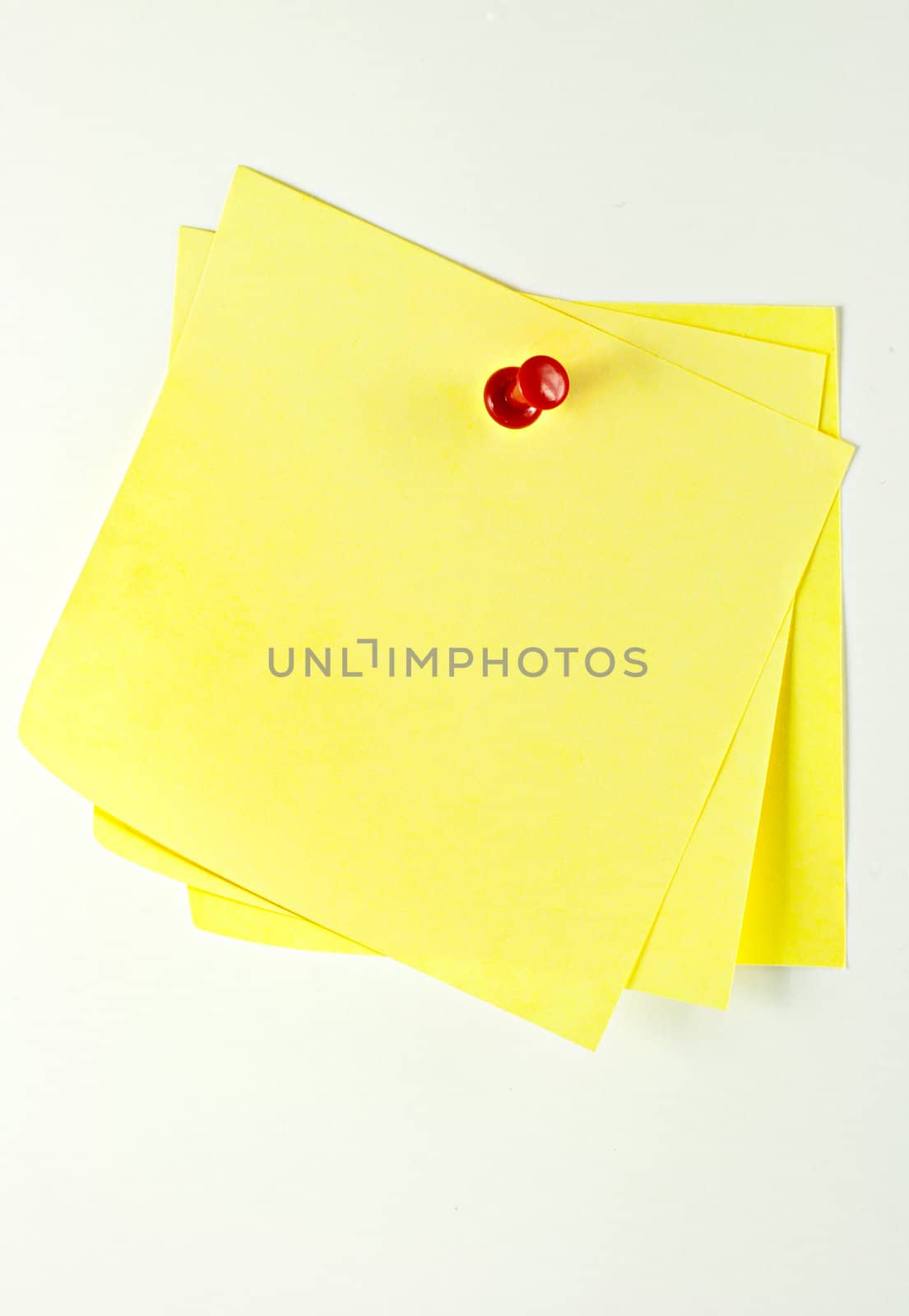 Three yellow sticky paper pinned with a pin at a white background.
