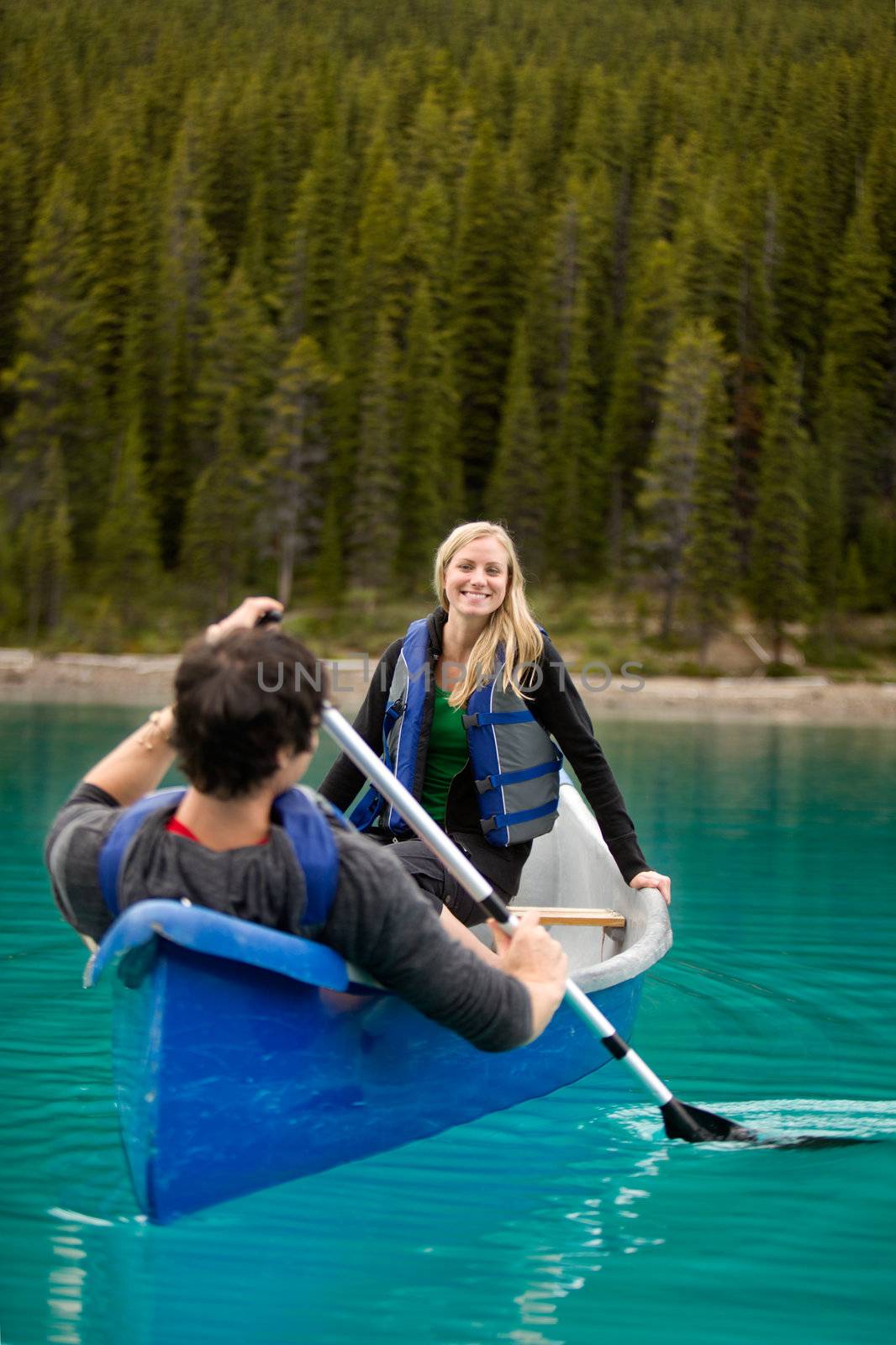 A happy couple canoeing on a glacial lake
