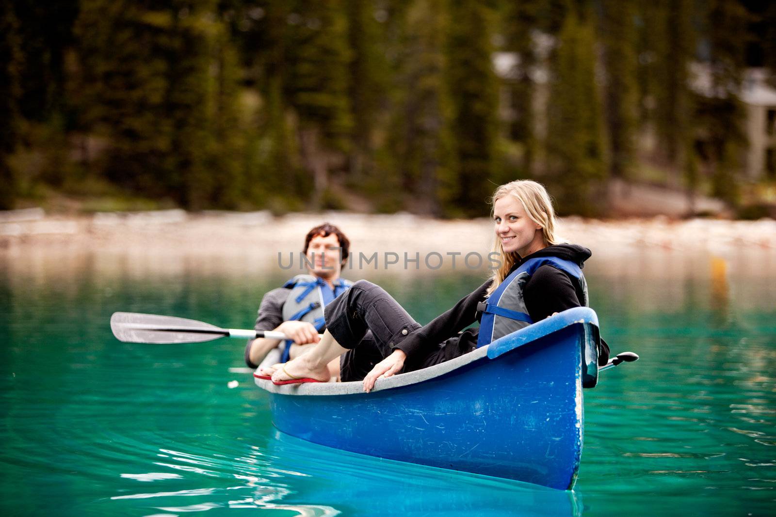 A happy couple relaxing in a canoe on a glacial lake