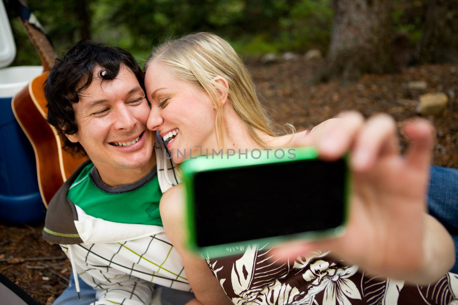 A happy playful couple on a picnic taking a self portrait