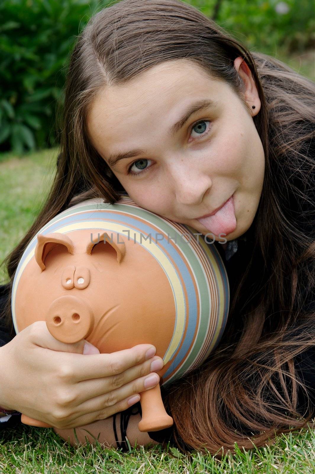 girl with a piggy bank sticking out her tongue