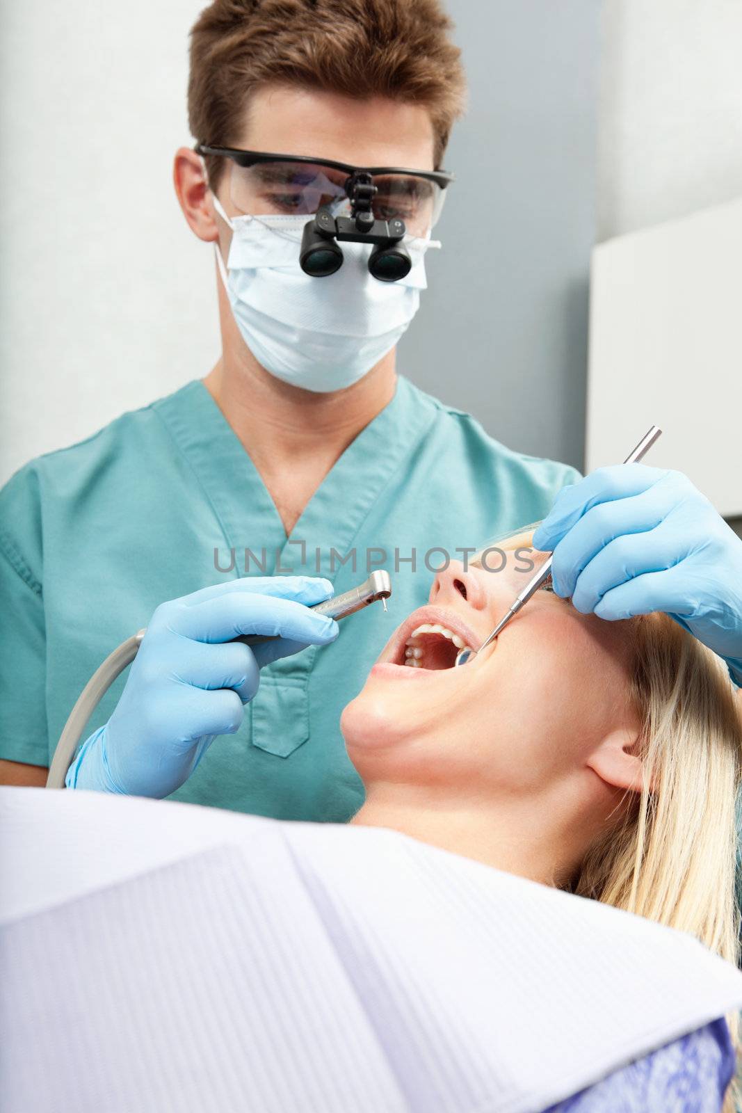 Male dentist examining a female's teeth