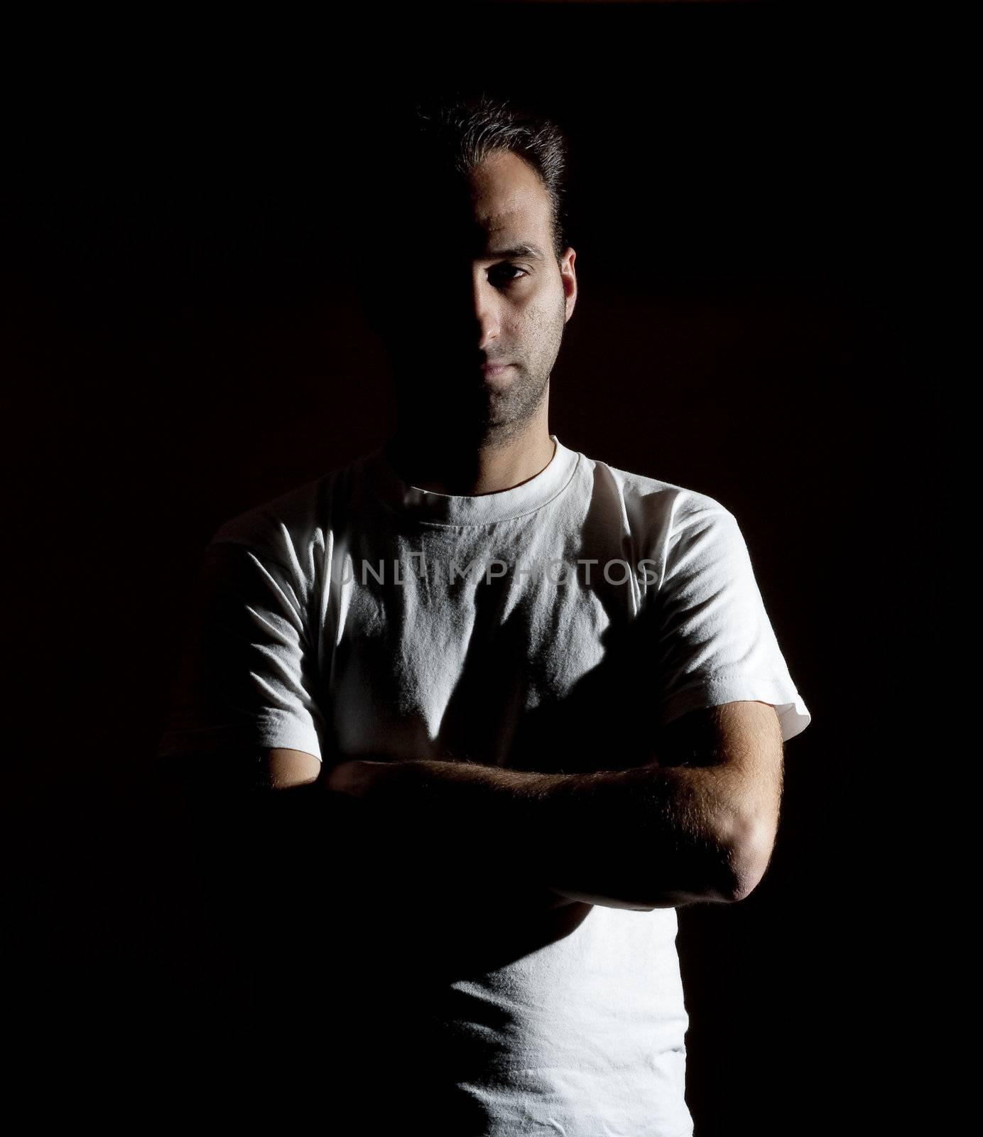 dark image of a no shaved dangerous looking guy in a rude pose