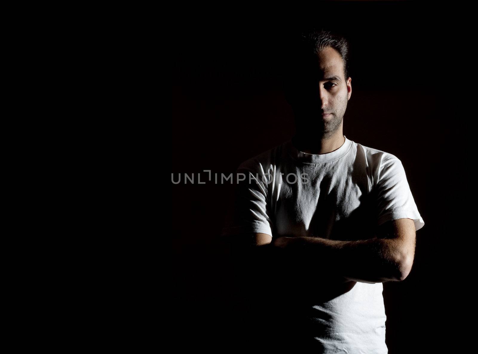 dark image of a no shaved dangerous looking guy in a rude pose