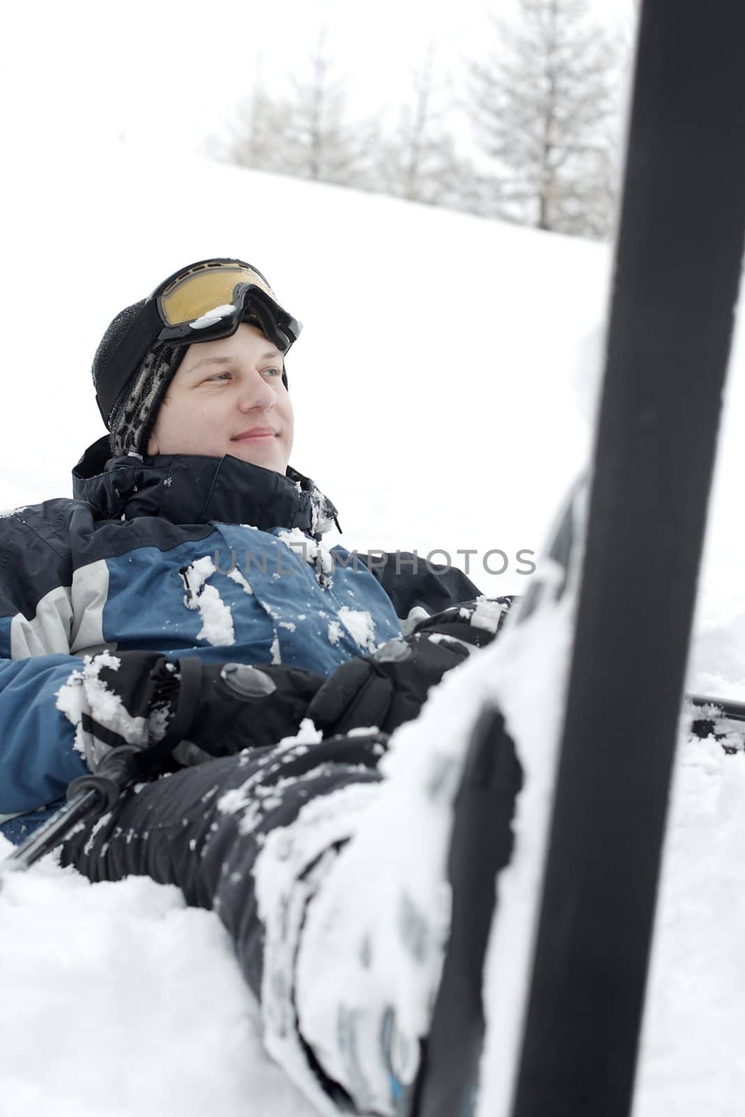 Young skier resting in the snow