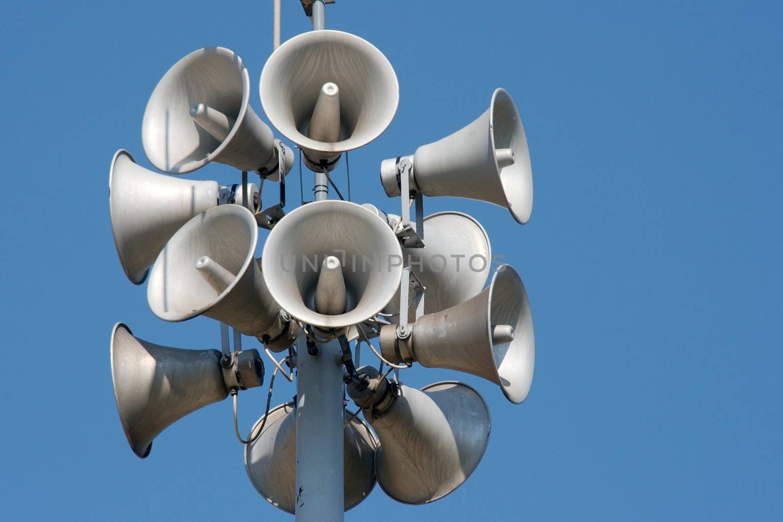 Lots of white loudspeakers on a column