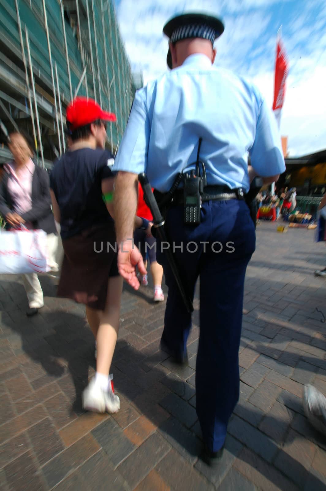 cop in blue uniform arresting or investigating a young man, picture is motion blurred
