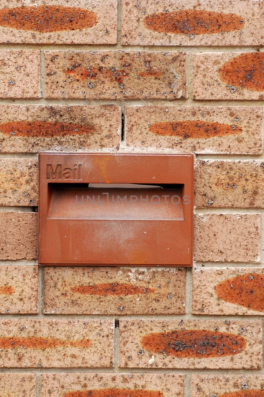 red mailbox in red brick wall, detail photo