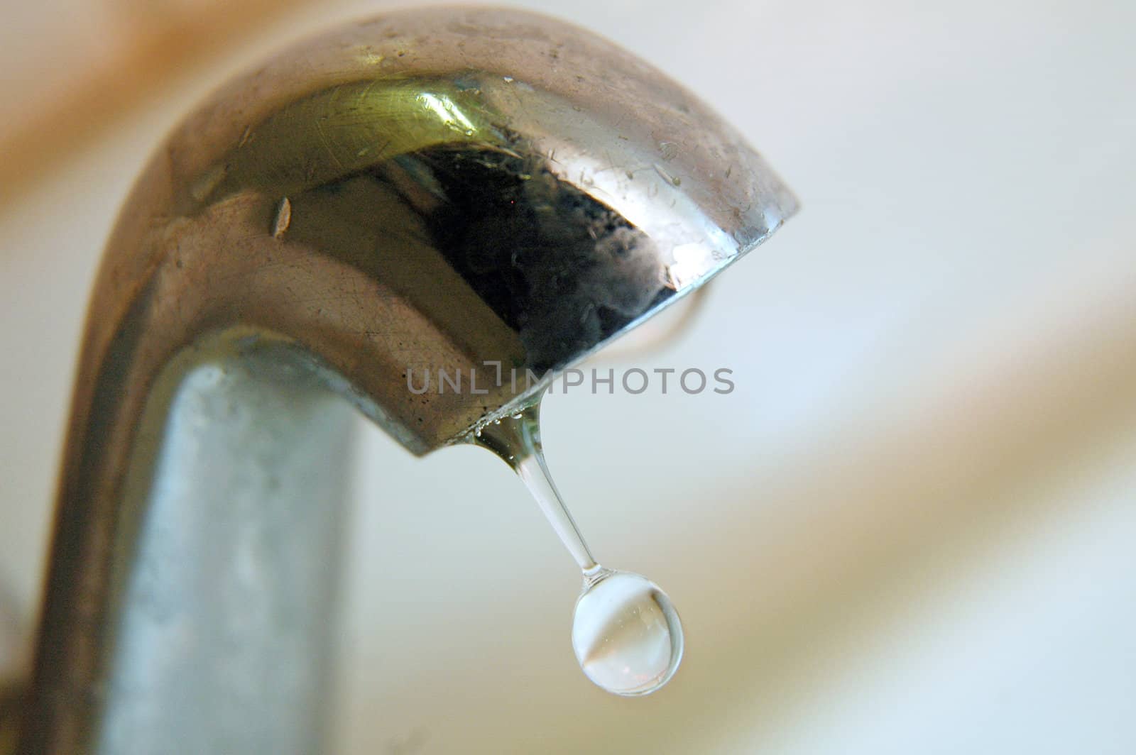 macro photo of draw-off tap with one water drop 