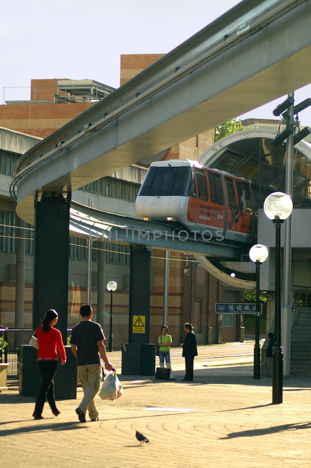 train departing from station, pedestrians under bridge